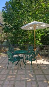 a table and two chairs with an umbrella at Nature's Hideaway Homestay in Ban Lam Thong Lang