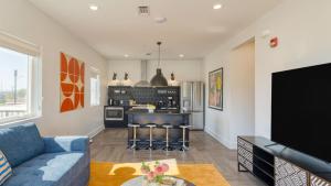 a living room with a blue couch and a kitchen at The Carter by AvantStay in Nashville