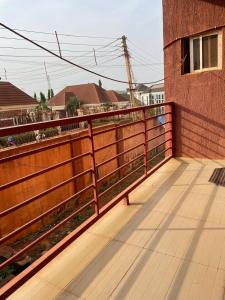 a wooden deck with a fence next to a building at Modern 1 Bedroom Apartment with Balcony in Enugu