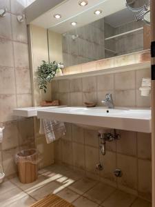 a bathroom with a sink and a mirror at Das CLASSIQUE Galerieappartement 45qm - Elegant und geräumig wohnen - Espressomaschine, Airfryer, ruhiger Balkon, Poseidon Therme im Haus - inkl Parkgarage in Bad Griesbach