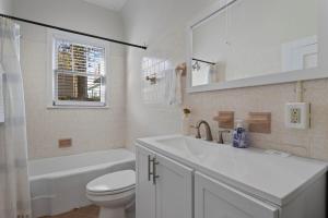 um banheiro com uma pia, um vaso sanitário e um espelho em Downtown Biloxi! Walkable to the Beach & Casinos! em Biloxi mais 33 fotografias