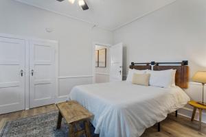 um quarto branco com uma cama grande e uma mesa em Downtown Biloxi! Walkable to the Beach & Casinos! em Biloxi