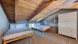 a attic bedroom with a bed and a chair at Lakeview by AvantStay Private Waterfront Cabin on Lake Tahoe w Hot Tub Views in Tahoe Vista