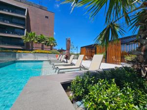 a swimming pool with chaise lounge chairs next to a building at Skyline Moinhos de Vento in Porto Alegre
