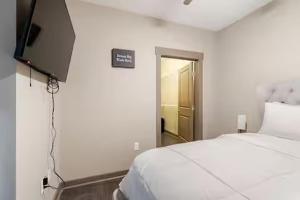 a bedroom with a bed and a tv on the wall at Queen City Getaway with Pool in Charlotte +18 photos