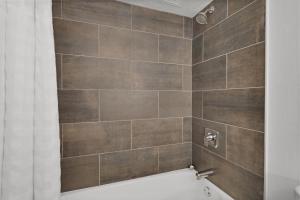 y baño con ducha de azulejos marrones. en World of Blue 713 I Beautiful QQ Hotel Rooms, en Secaucus 12 fotos más