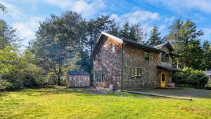 una vieja casa de ladrillo con un patio en Walk to Beach Relax in Hot Tub Dine on the Deck LoLis Place by AvantStay, en Arch Cape
