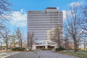 un edificio alto con un estacionamiento delante de él en World of Blue 715 I Beautiful QQ Hotel Rooms, en Secaucus