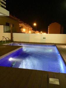 een zwembad 's nachts met blauwe lichten bij Jardins da Parede Villa in Parede