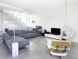 een woonkamer met een bank en een stoel bij Jardins da Parede Villa in Parede