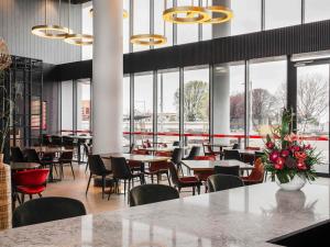 德文港Novotel Devonport的一家有桌椅和窗户的餐厅