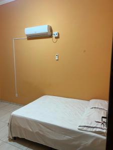 una camera con un letto e un condizionatore a muro di Pousada Beira Rio a Rio da Conceição