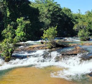 un fiume con rapide in cima a rocce e alberi di Pousada Beira Rio a Rio da Conceição