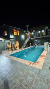 an empty swimming pool at night with a building at Alojamiento Napoleon in Puerto Iguazú