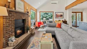 Waterside Haven by AvantStay Lakefront Hot Tub Game Room Fire Pit في Long Pond: غرفة معيشة مع أريكة ومدفأة