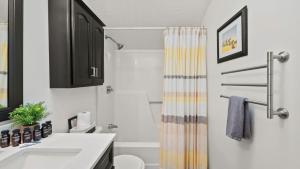 Waterside Haven by AvantStay Lakefront Hot Tub Game Room Fire Pit في Long Pond: حمام مع مغسلة وستارة دش +41 صورة