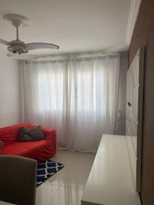 a living room with a red couch and a window at Cintia Luiza in Aracaju