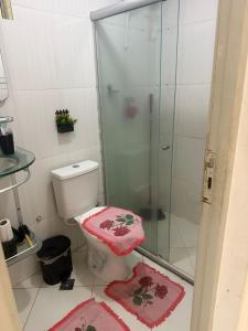 a bathroom with a shower and a toilet with pink mats at Gilvan Rocha in Aracaju