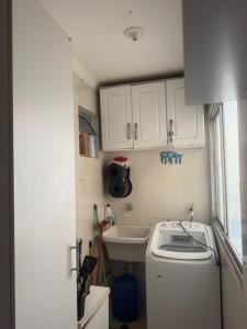 a small kitchen with a sink and a washing machine at Gilvan Rocha in Aracaju