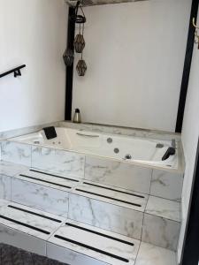 una vasca da bagno con ripiani in marmo in una stanza di Secrect Jacuzzi Studio a San Miguel de Allende