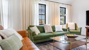 a living room with a green couch and a coffee table at Charcoal Chalet by AvantStay A Design w Firepit in New Paltz