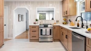 a kitchen with wooden cabinets and a stove top oven at Charcoal Chalet by AvantStay A Design w Firepit in New Paltz