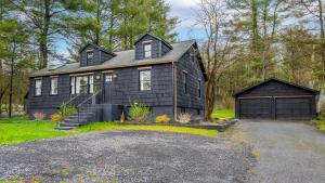 a black house with a garage in front of it at Charcoal Chalet by AvantStay A Design w Firepit in New Paltz