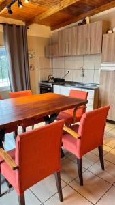 a kitchen with a wooden table and orange chairs at Alojamiento Napoleon in Puerto Iguazú