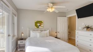 Sleeps 28 Beachfront w Pool Hot Tub Game Room Atlantic Watch by AvantStay في كيل ديفيل هيلز: غرفة نوم بسرير أبيض ومروحة سقف +55 صورة