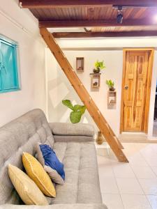 a living room with a couch with blue and yellow pillows at Cabaña frente al Río-Curití-San Gil in Curití