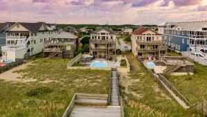 Sleeps 28 Beachfront w Pool Hot Tub Game Room Atlantic Watch by AvantStay في كيل ديفيل هيلز: اطلالة جوية على حي سكني فيه بيوت