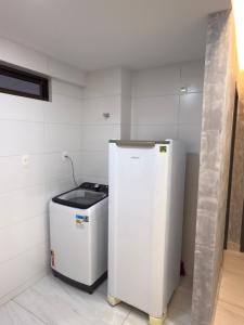 a small white refrigerator in a white room with at Comfort and elegance in the heart of Cabo Branco in João Pessoa +29 photos
