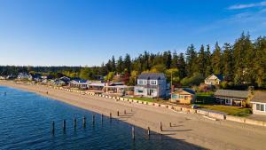 a row of houses on a beach next to the water at Cozy Whidbey Island Stay Steps to the beach Fireplace BBQ Near Trails in Freeland