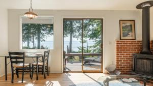 a living room with a table and chairs and a fireplace at Mutiny Bay Waterfront Cabin by AvantStay Views in Freeland