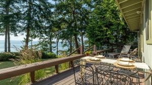 a wooden deck with a table and chairs on it at Mutiny Bay Waterfront Cabin by AvantStay Views in Freeland