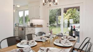 Marine View Bluff by AvantStay Waterfront Views في Greenbank: غرفة طعام مع طاولة وكراسي ومطبخ