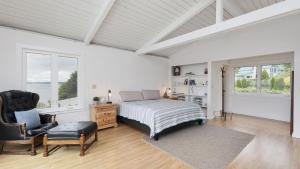 Marine View Bluff by AvantStay Waterfront Views في Greenbank: غرفة نوم بها سرير وكرسي ونوافذ