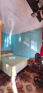 una cama en una habitación con una pared azul en La Estancia, en Lanquín