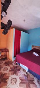 Un dormitorio con una cama con una manta roja encima. en La Estancia, en Lanquín