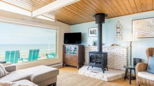 a living room with a fireplace and a tv at West Beach Wonderland by AvantStay Waterfront in Oak Harbor