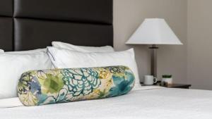 Una almohada encima de una cama con una lámpara. en CozySuites Remi sauna, pool, gym, en Dallas