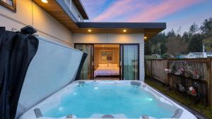 a hot tub in the backyard of a house at Chic Whidbey Island Waterfront Home w Hot Tub Firepits Views in Coupeville