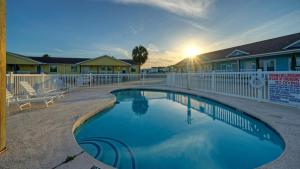 a swimming pool in front of a house with a fence at Stylish 2BR Coastal Getaway w Pool Prime Location Lazy Fun in Port Aransas