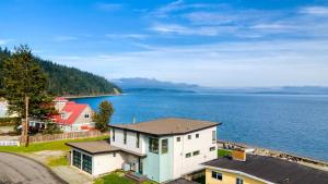 an aerial view of a house next to the water at Chic Whidbey Island Waterfront Home w Hot Tub Firepits Views in Coupeville