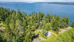 an aerial view of a house in the trees near the water at Mid-Century Beach Cabin by AvantStay Walk to Beach in Coupeville