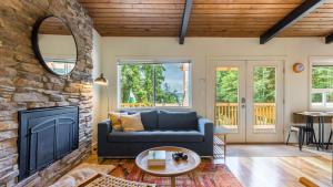 a living room with a couch and a fireplace at Mid-Century Beach Cabin by AvantStay Walk to Beach in Coupeville +33 photos