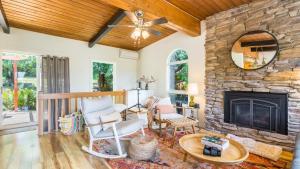 a living room with a stone fireplace at Mid-Century Beach Cabin by AvantStay Walk to Beach in Coupeville