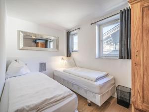 Dos camas en una habitación pequeña con ventana. en Chalet Adriana, en Kirchberg in Tirol