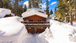 a log cabin is covered in snow at Explorer by AvantStay Close to Slopes Game Room Guest Suite Hot Tub in Alpine Meadows