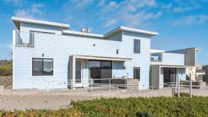 a white house on the beach with at Beachfront 2BR w Deck Views Direct Sand Access Strand Way A in Oceano